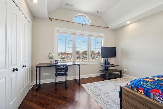 bedroom with lofted ceiling, a closet, visible vents, and wood finished floors