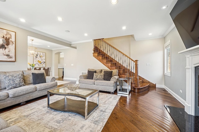 living area with stairs, crown molding, arched walkways, dark wood-style floors, and baseboards
