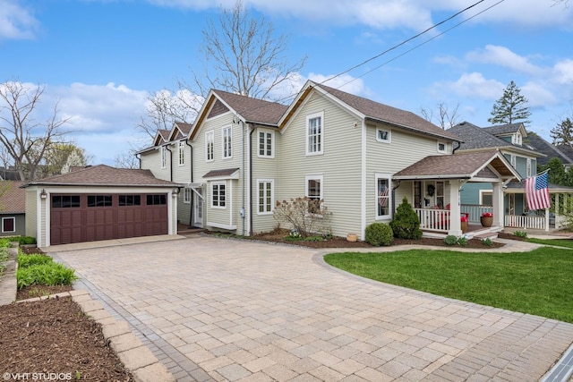 view of front of home featuring an outdoor structure, driveway, covered porch, and a front yard