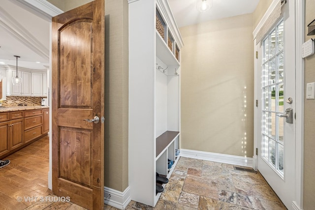 mudroom with baseboards, visible vents, and stone finish floor