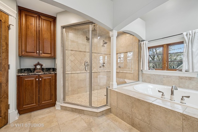 full bathroom featuring ornate columns, tile patterned flooring, a shower stall, and a bath