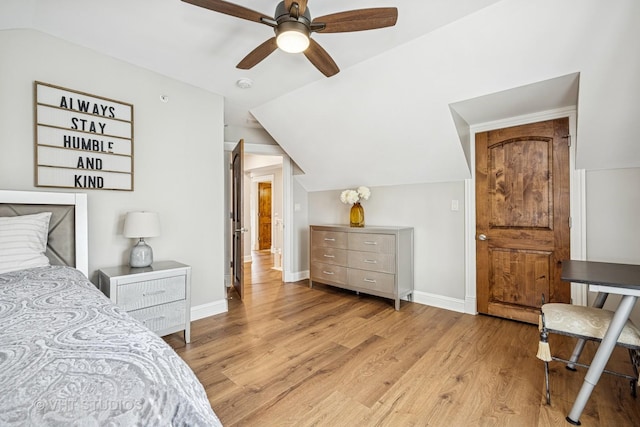 bedroom featuring baseboards, ceiling fan, light wood-style flooring, and lofted ceiling