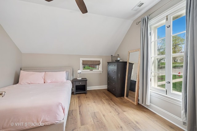 bedroom featuring ceiling fan, visible vents, baseboards, light wood finished floors, and lofted ceiling