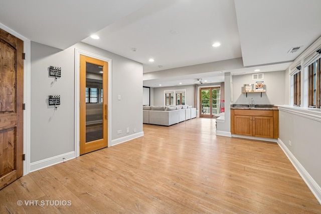 interior space with indoor wet bar, recessed lighting, and light wood-style flooring