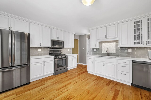 6650 Powell St, Downers Grove, IL 60516 - kitchen featuring light wood-type flooring, tasteful backsplash, light countertops, a sink, and stainless steel appliances