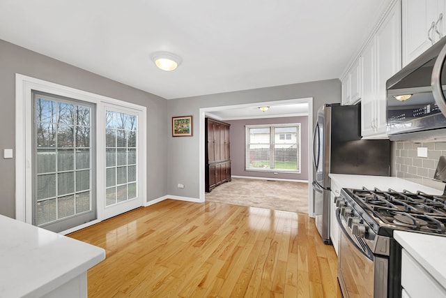 6650 Powell St, Downers Grove, IL 60516 - kitchen with light wood-style floors, white cabinets, stainless steel microwave, light countertops, and gas range oven