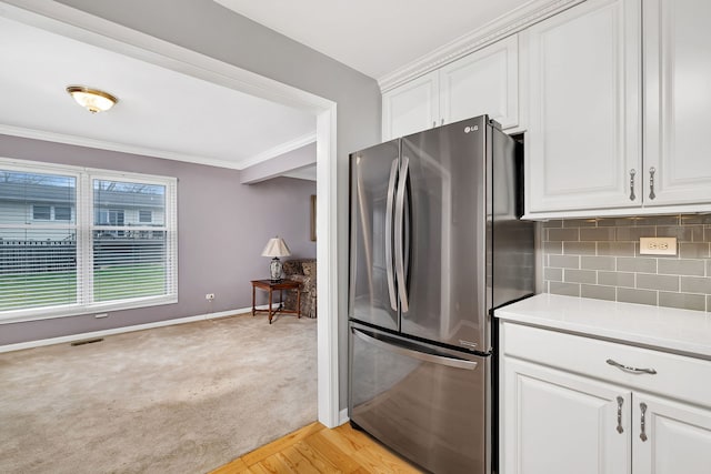 6650 Powell St, Downers Grove, IL 60516 - kitchen with crown molding, freestanding refrigerator, visible vents, light countertops, and backsplash