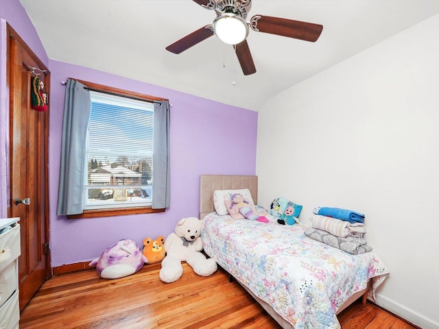 bedroom featuring wood finished floors, baseboards, a ceiling fan, and vaulted ceiling