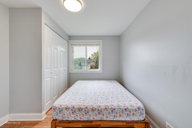 bedroom featuring a closet, baseboards, and light wood-style floors
