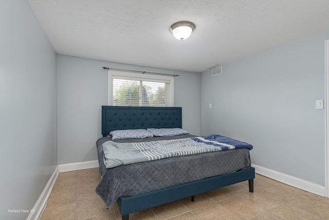 bedroom with baseboards, tile patterned flooring, and visible vents