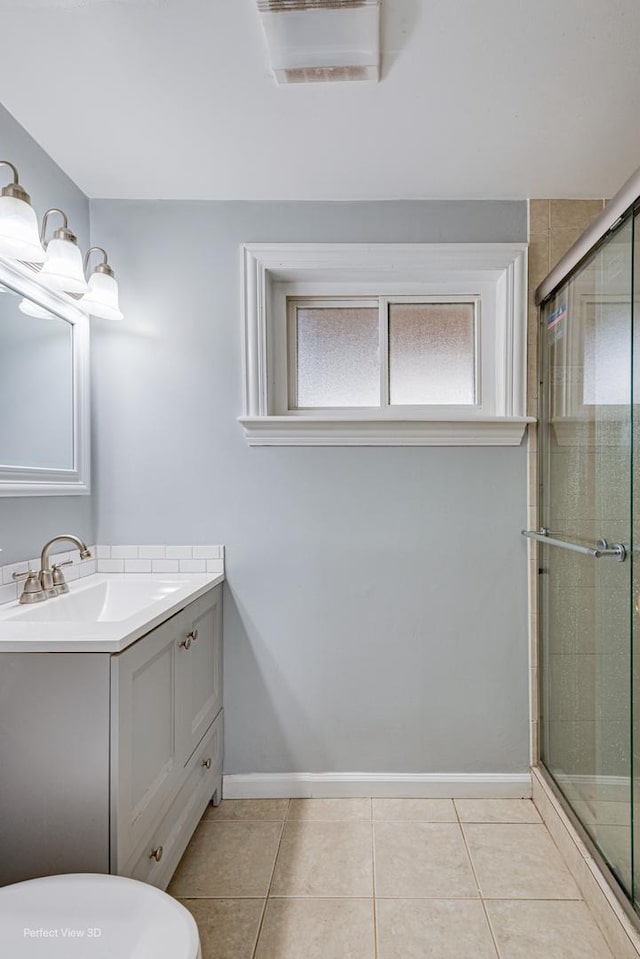 full bathroom featuring vanity, baseboards, tile patterned floors, and tiled shower