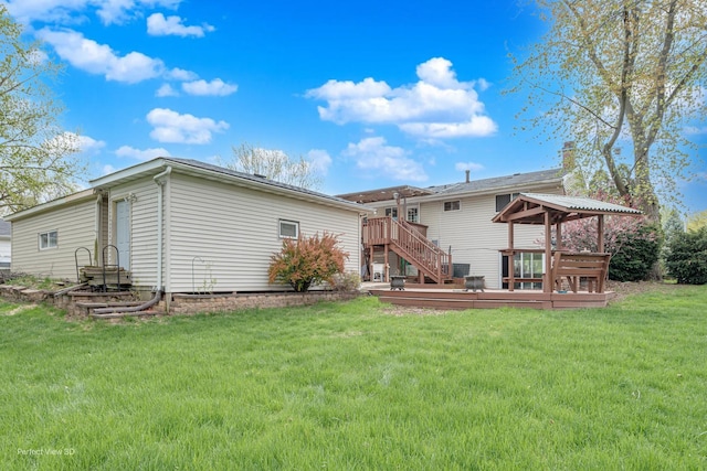 rear view of property featuring a lawn, stairway, and a deck