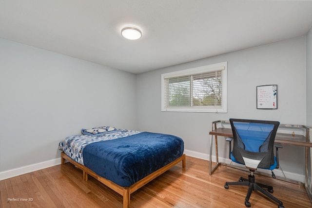 bedroom with baseboards and wood finished floors
