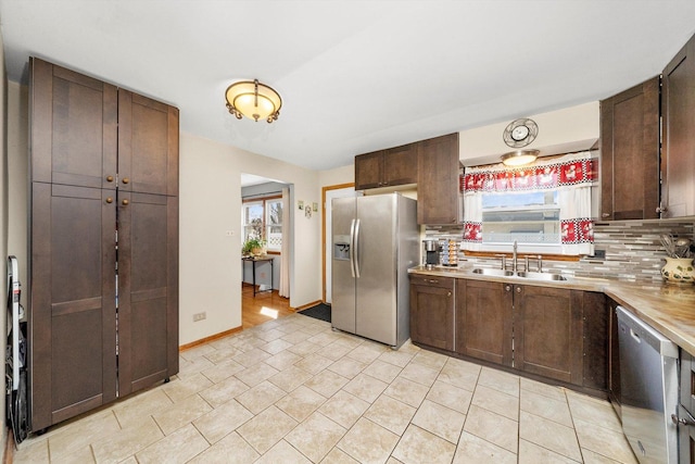 609 Chippewa Ln, Darien, IL 60561 - kitchen with dark brown cabinetry, light countertops, a sink, stainless steel appliances, and backsplash