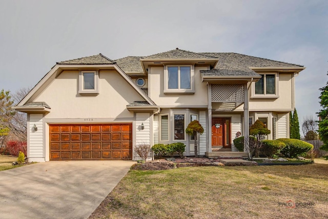 view of front of property featuring a front yard, driveway, and stucco siding