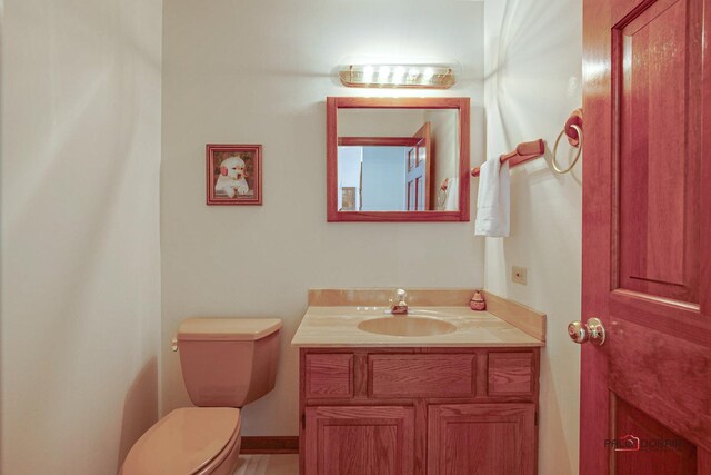 half bathroom featuring vanity and toilet