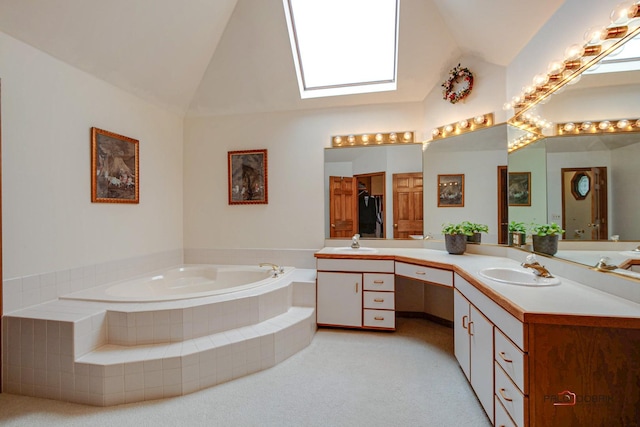 full bathroom featuring a bath, vanity, and lofted ceiling with skylight