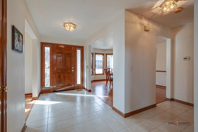 foyer entrance featuring baseboards and light tile patterned flooring