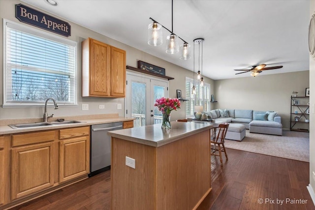 kitchen featuring a center island, a ceiling fan, dark wood finished floors, stainless steel dishwasher, and a sink