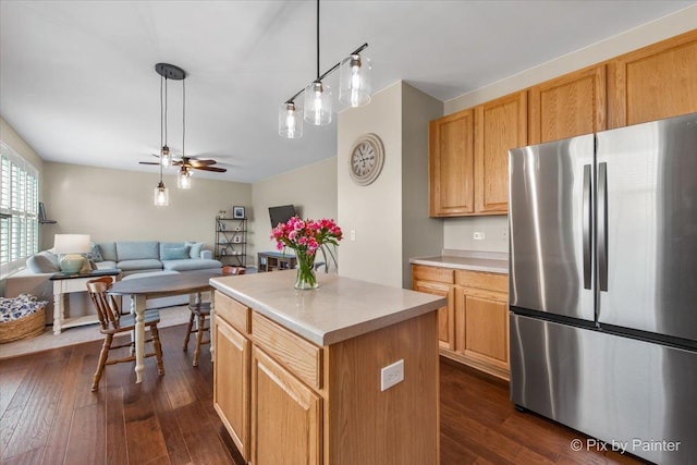 kitchen featuring ceiling fan, freestanding refrigerator, dark wood-style flooring, light countertops, and open floor plan