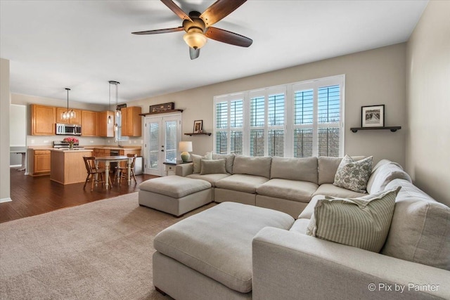 living area with a ceiling fan and dark wood-style floors