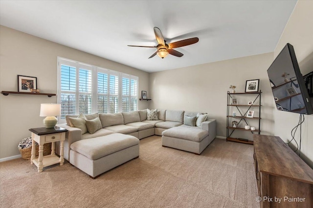 living room featuring ceiling fan, light carpet, and baseboards