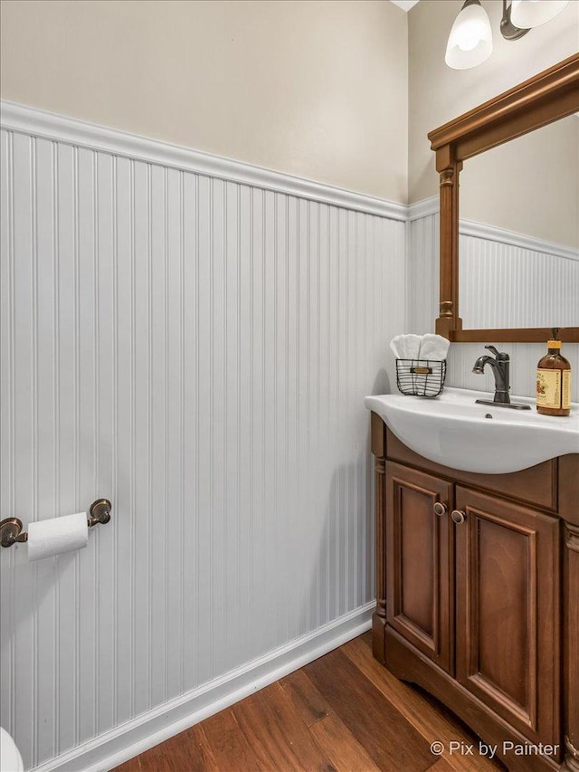 bathroom with vanity, a wainscoted wall, and wood finished floors