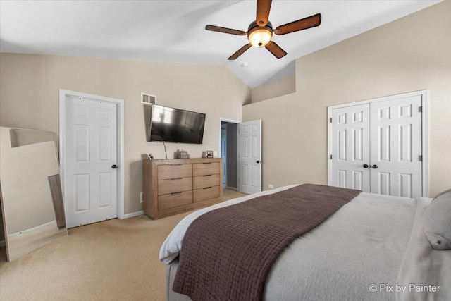bedroom featuring a closet, light colored carpet, a ceiling fan, visible vents, and lofted ceiling