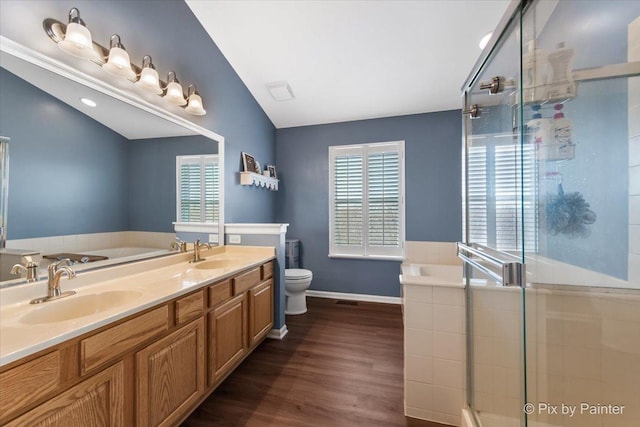 bathroom with a garden tub, a sink, and wood finished floors