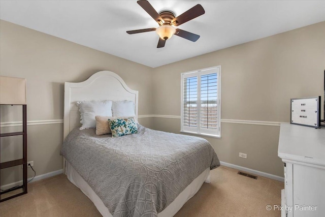 carpeted bedroom featuring visible vents, baseboards, and ceiling fan