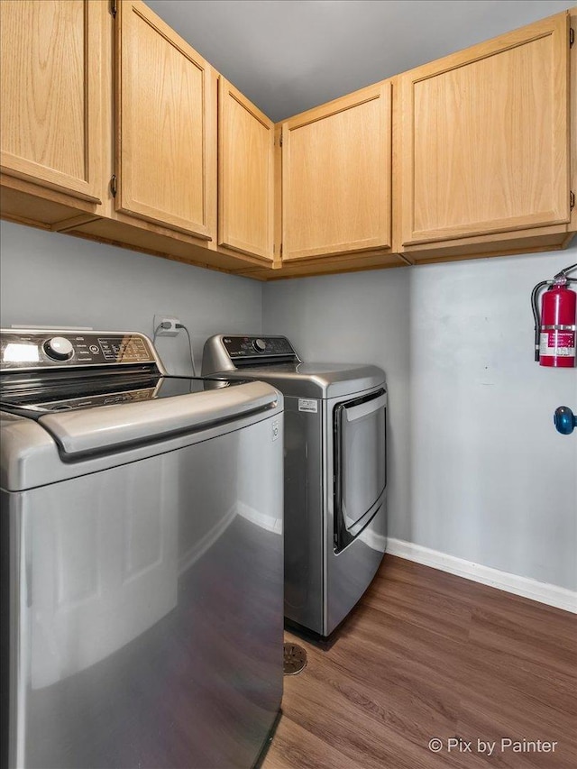 clothes washing area featuring cabinet space, baseboards, separate washer and dryer, and dark wood finished floors