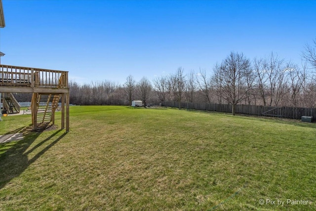 view of yard featuring stairs, a wooden deck, and fence
