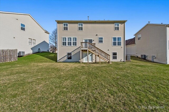 rear view of property with stairway, cooling unit, fence, and a lawn