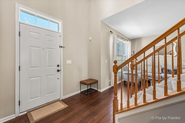 foyer entrance featuring stairs, dark wood-style flooring, and baseboards