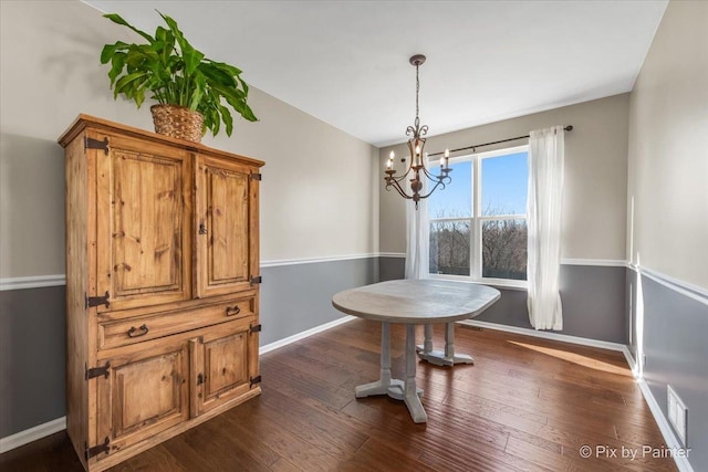 dining space with dark wood-style flooring, visible vents, baseboards, and an inviting chandelier