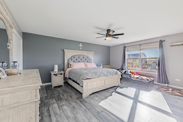 bedroom with dark wood-type flooring, ceiling fan, and baseboards
