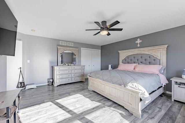 bedroom featuring visible vents, baseboards, a closet, and wood finished floors