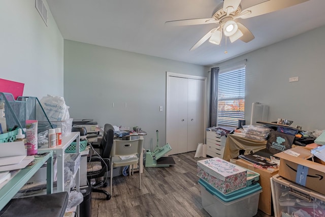 office space featuring wood finished floors, a ceiling fan, and visible vents