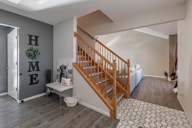 stairway featuring baseboards and wood finished floors