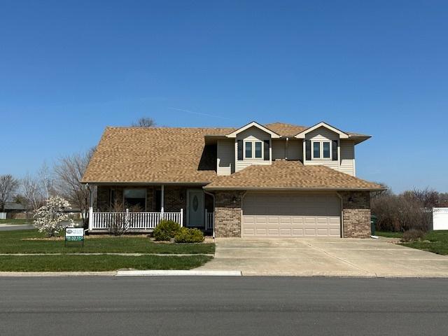 110 E Spring Rd, Coal City, IL 60416 - traditional-style home featuring driveway, a front lawn, brick siding, a garage, and covered porch