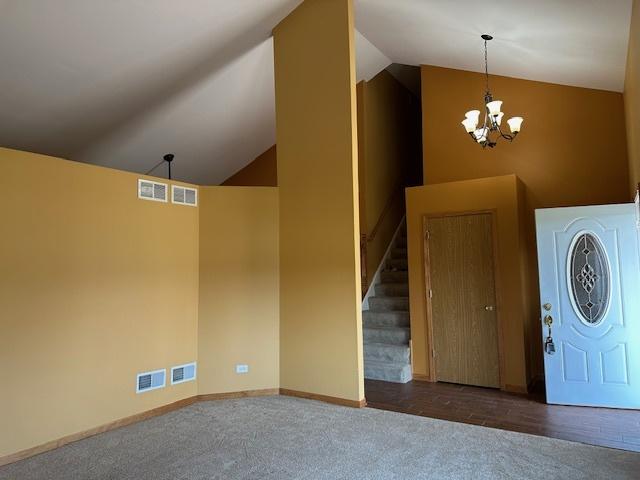 110 E Spring Rd, Coal City, IL 60416 - carpeted foyer entrance featuring visible vents, a notable chandelier, lofted ceiling, and stairs
