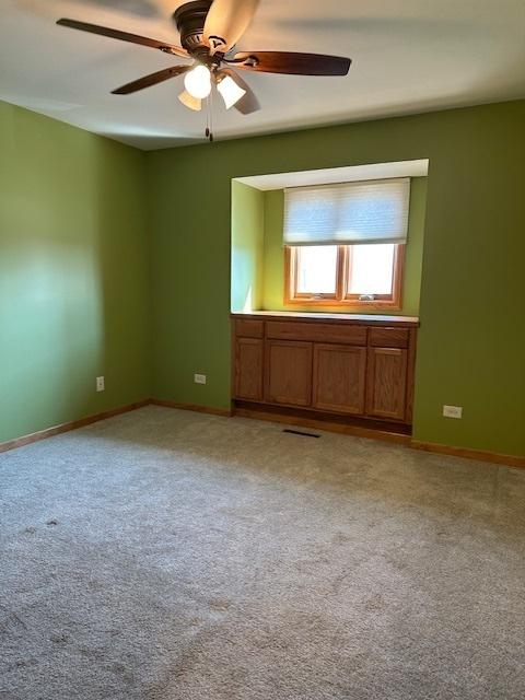 110 E Spring Rd, Coal City, IL 60416 - spare room with light carpet, baseboards, a ceiling fan, and visible vents