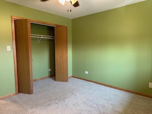 110 E Spring Rd, Coal City, IL 60416 - unfurnished bedroom with carpet flooring, a closet, baseboards, and a ceiling fan