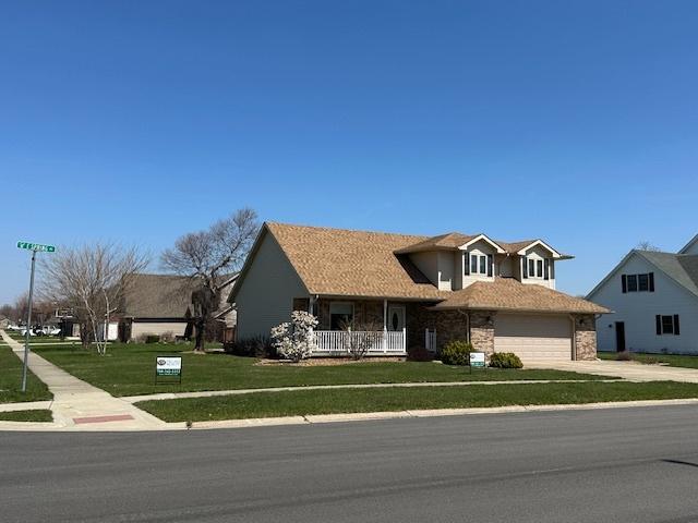 110 E Spring Rd, Coal City, IL 60416 - view of front of house with a porch, stone siding, a garage, concrete driveway, and a front lawn