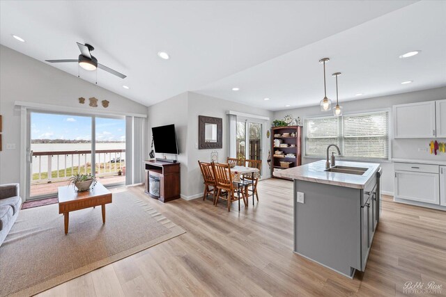 kitchen featuring a sink, baseboards, stainless steel appliances, and white cabinetry