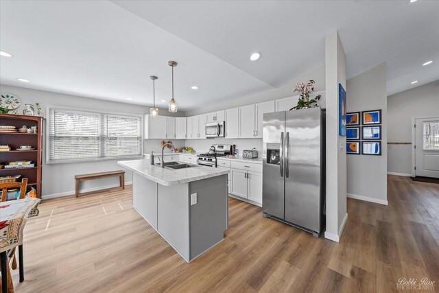 kitchen featuring a sink, baseboards, stainless steel appliances, and white cabinetry