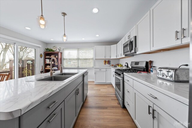 kitchen with recessed lighting, a sink, appliances with stainless steel finishes, and a wealth of natural light