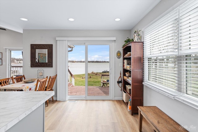 interior space with a water view, recessed lighting, and light wood-style flooring