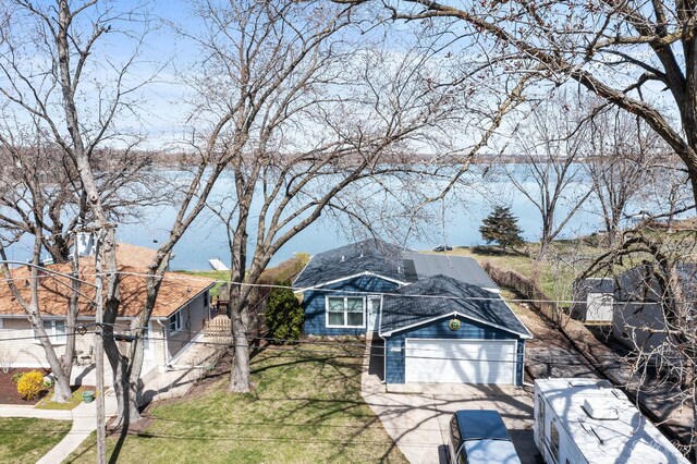 view of front of home featuring a garage, fence, concrete driveway, and a front lawn