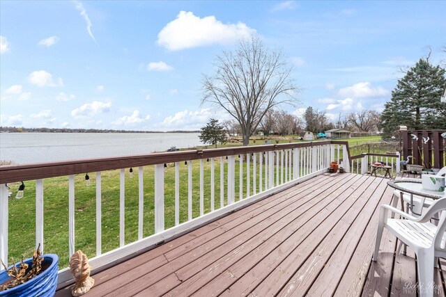 wooden terrace with a lawn and a water view